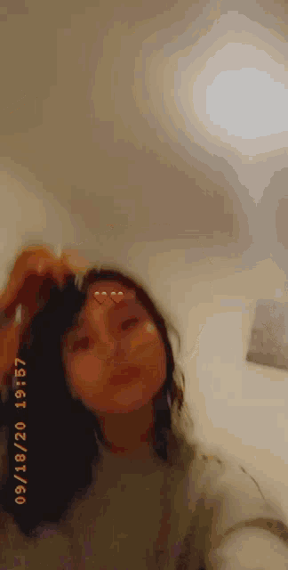 a woman is taking a selfie with a heart on her face while wearing a sweater .