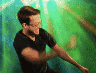 a man in a black shirt is dancing in front of a green backdrop