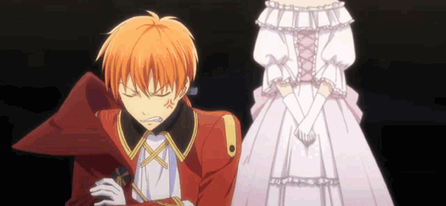 a man in a red suit stands next to a woman in a white dress