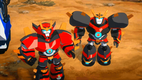 two transformers are standing next to each other on a dirt ground