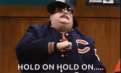 a man wearing a bears jacket and tie is dancing and says `` hold on hold on ... '' .