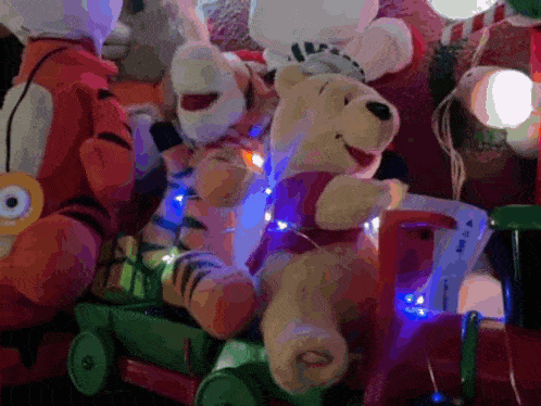 a winnie the pooh stuffed animal is sitting on a green toy train