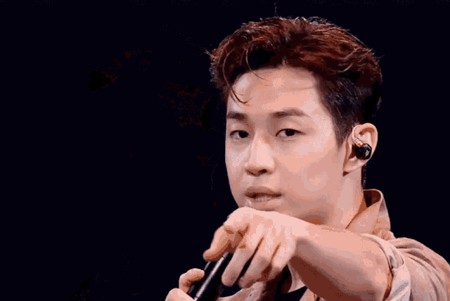 a man is holding a microphone in his right hand