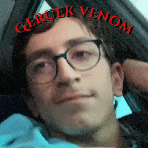 a close up of a man with glasses and the words gerçek venom above him