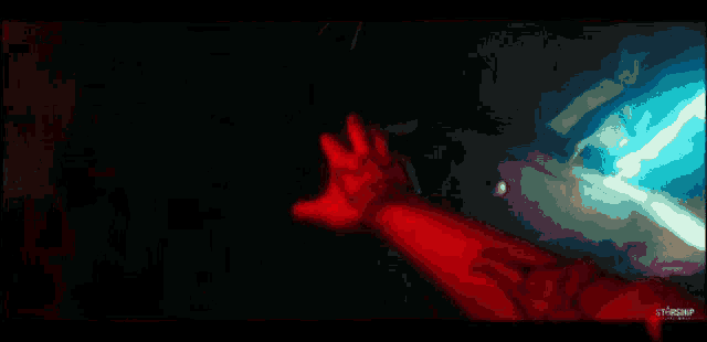 a close up of a person 's hand reaching out towards a light .