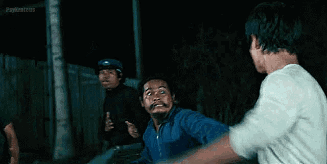 a group of men are fighting each other in a dark room in a movie .
