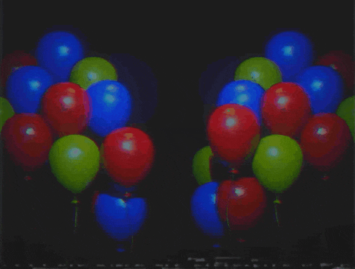 a bunch of balloons with a bear in the middle