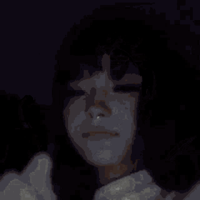 a close up of a person 's face in a dark room .