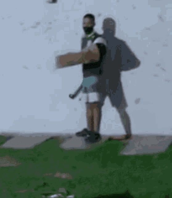 a man wearing a mask is holding a cardboard box in front of a wall .