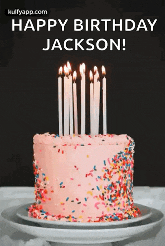 a birthday cake with candles and sprinkles on it is on a plate on a table .