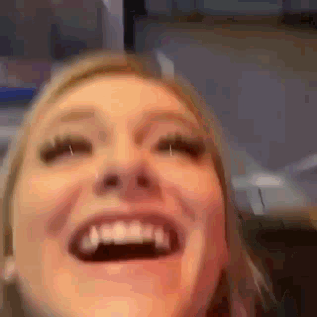 a close up of a woman 's face with her mouth open and teeth visible