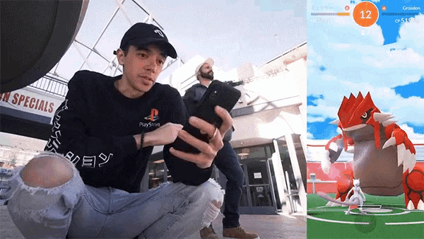 a man in a playstation shirt is taking a picture of another man