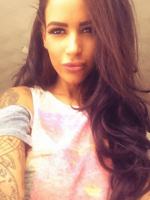 a woman with purple hair and a tattoo on her arm