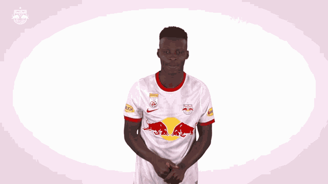 a man wearing a red bull jersey is making a fist gesture