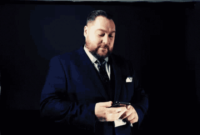 a man in a suit and tie is holding a cigarette in his hand