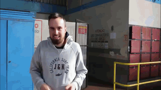 a man wearing a grey california surf team hoodie