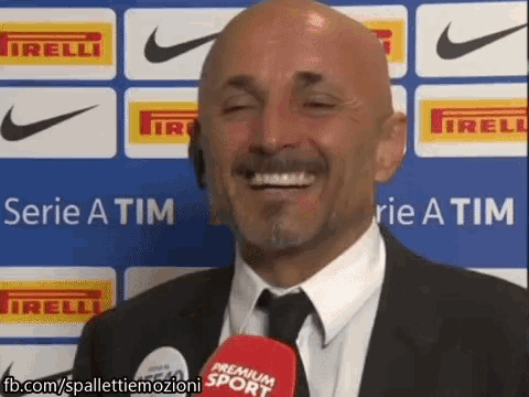 a bald man in a suit and tie is smiling in front of a series a tim banner