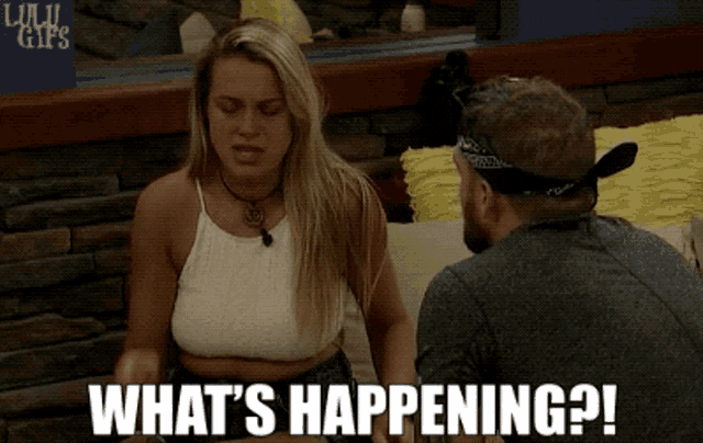 a man and a woman are sitting next to each other and the woman says what 's happening ?