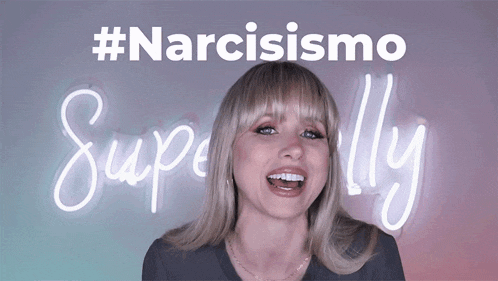 a woman is smiling in front of a neon sign that says narcisismo superally