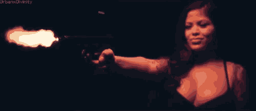 a woman is pointing a gun at the camera and the words urbanxdivinity are visible in the corner