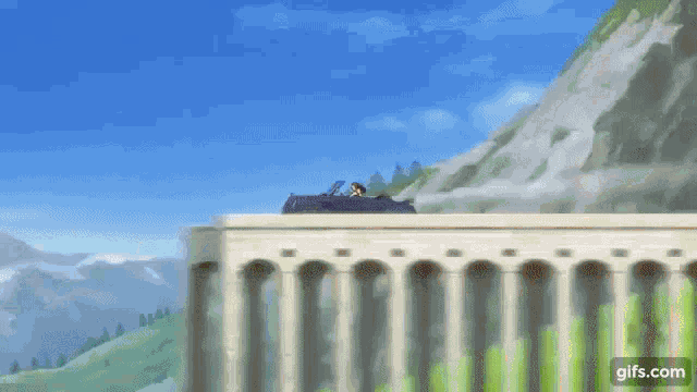 a car is flying over a bridge with mountains in the background .