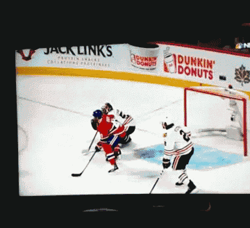 a hockey game is being played in front of a dunkin ' donuts advertisement