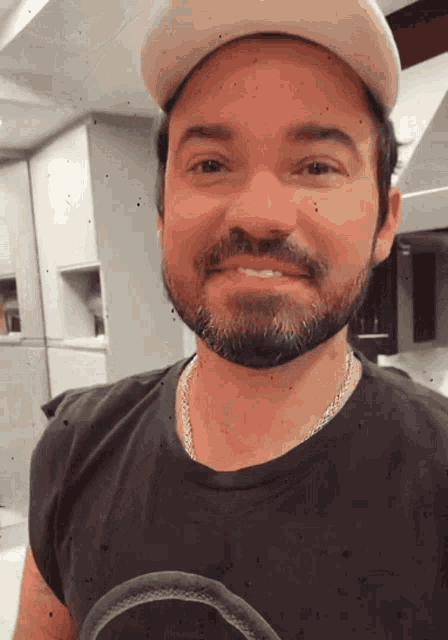 a man with a beard and hat is smiling