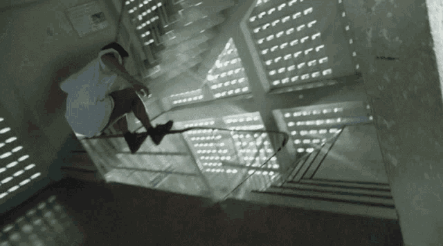 a person riding a skateboard down a set of stairs in a building