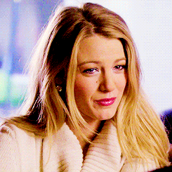 a close up of a woman 's face with a white sweater on