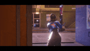 a woman in a blue and orange outfit is standing in a hallway