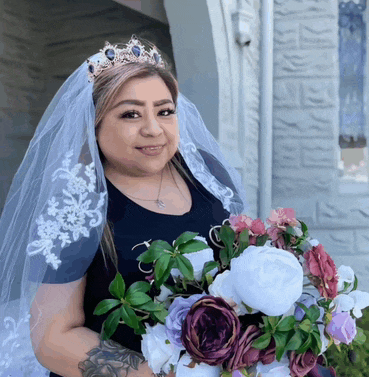 the bride is wearing a veil and tiara and holding a bouquet of flowers