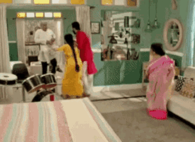 a group of people are dancing in a living room with a drum in the background .