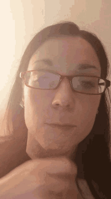 a close up of a woman 's face with glasses and earrings