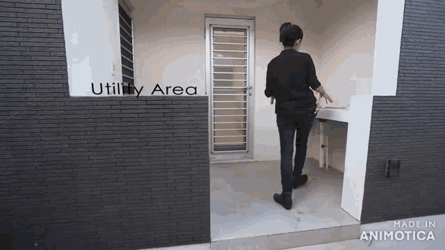 a woman is standing in front of a door that says utility area on it