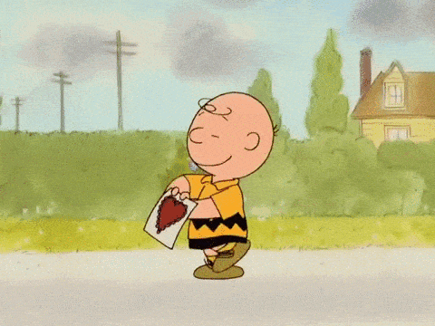 a cartoon of charlie brown holding a heart shaped object