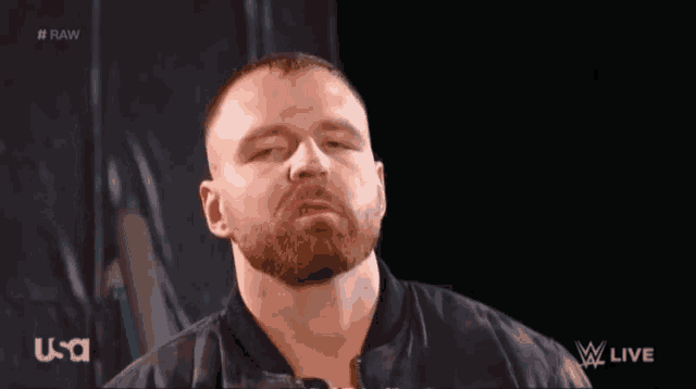 a man with a beard is wearing a black jacket .