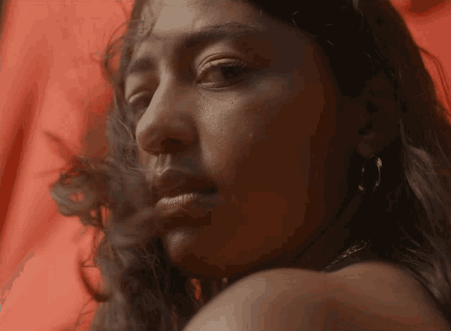 a close up of a woman 's face with long hair blowing in the wind
