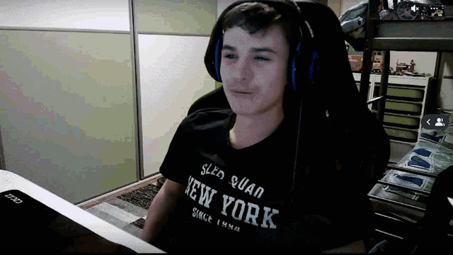 a young man wearing headphones and a black shirt that says new york