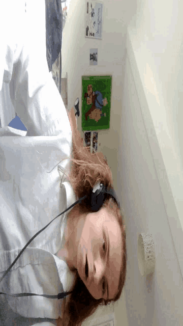a woman wearing headphones in a room with a picture of a bear on the wall behind her