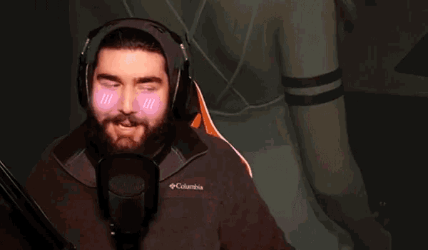 a man with a beard is wearing headphones and a columbia jacket
