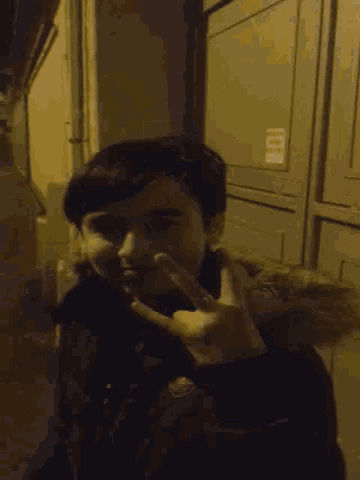 a young man giving the middle finger in front of a wall with the number 101 on it