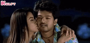 a man and a woman are kissing each other on the cheek .