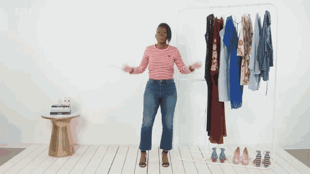a woman is standing in front of a rack of clothes with the word elle on the bottom right