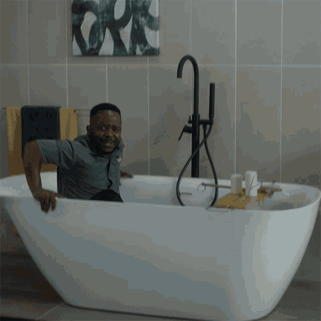 a man sitting in a bathtub with a painting above him that says york