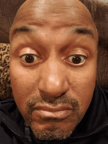 a close up of a man 's face with a beard and brown eyes