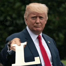 a man in a suit and tie is holding a letter l in his hand