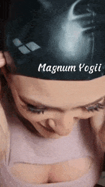 a woman wearing a black swim cap with magnum yogii written on the top