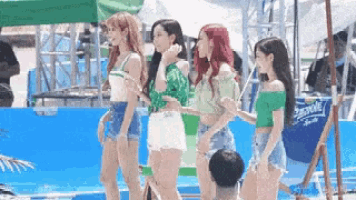 a group of girls are standing next to each other in front of a sprite sign