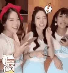 three women are sitting next to each other and smiling while holding their cell phones .