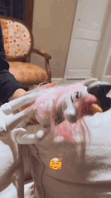 a person is holding a unicorn with pink hair